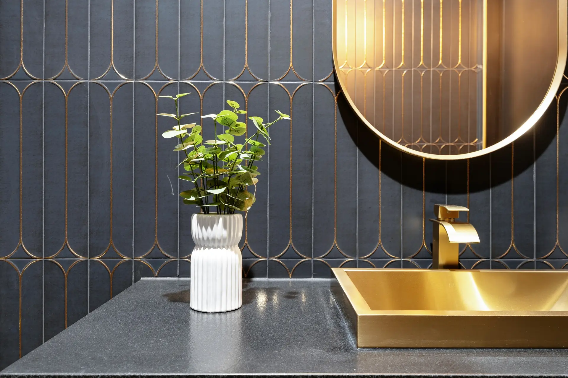 Bluewater Residence powder room vanity with brass sink and oval mirror in Lago Vista, Texas