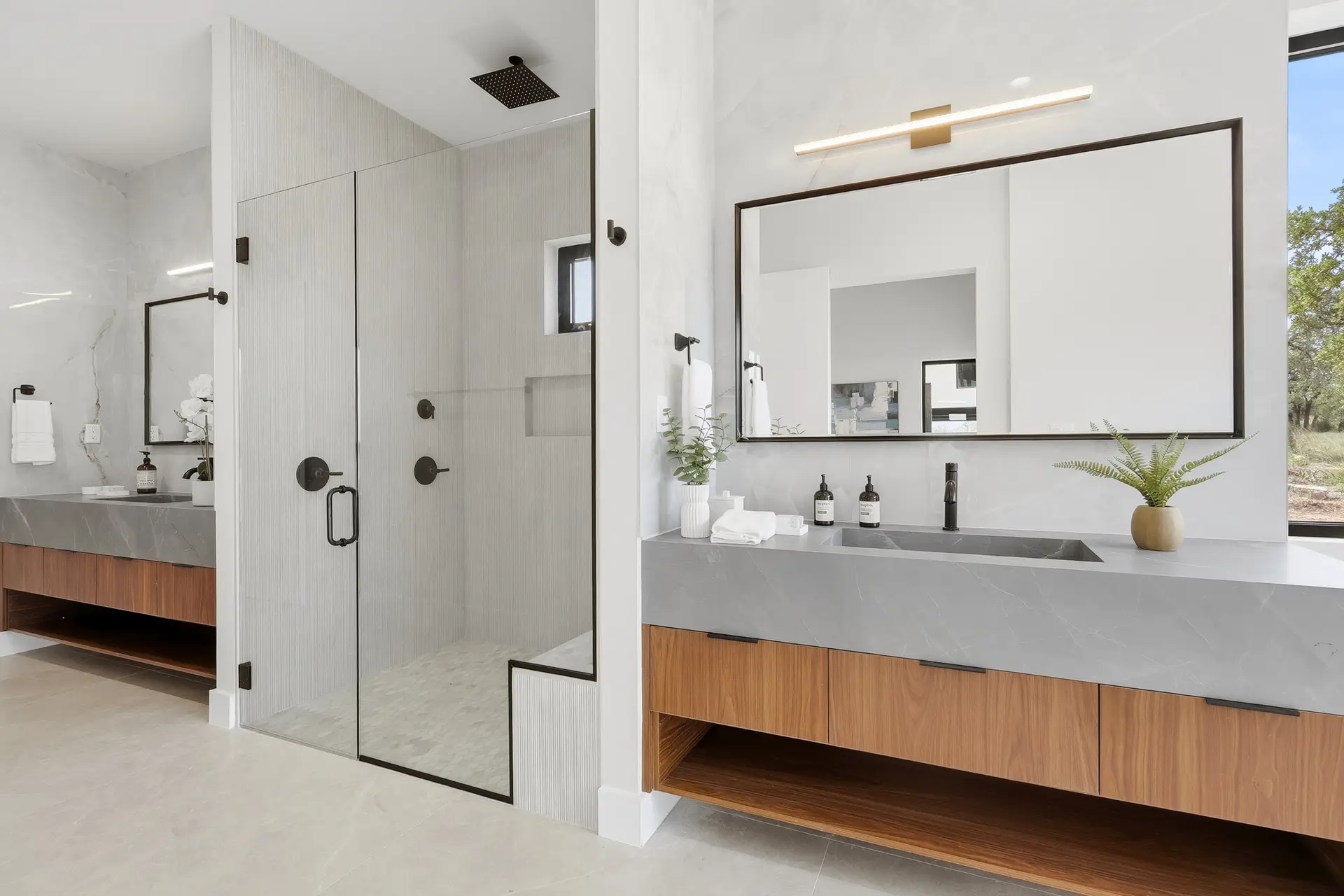 Bluewater Residence bathroom with glass walk-in shower and walnut vanity in Lago Vista, Texas