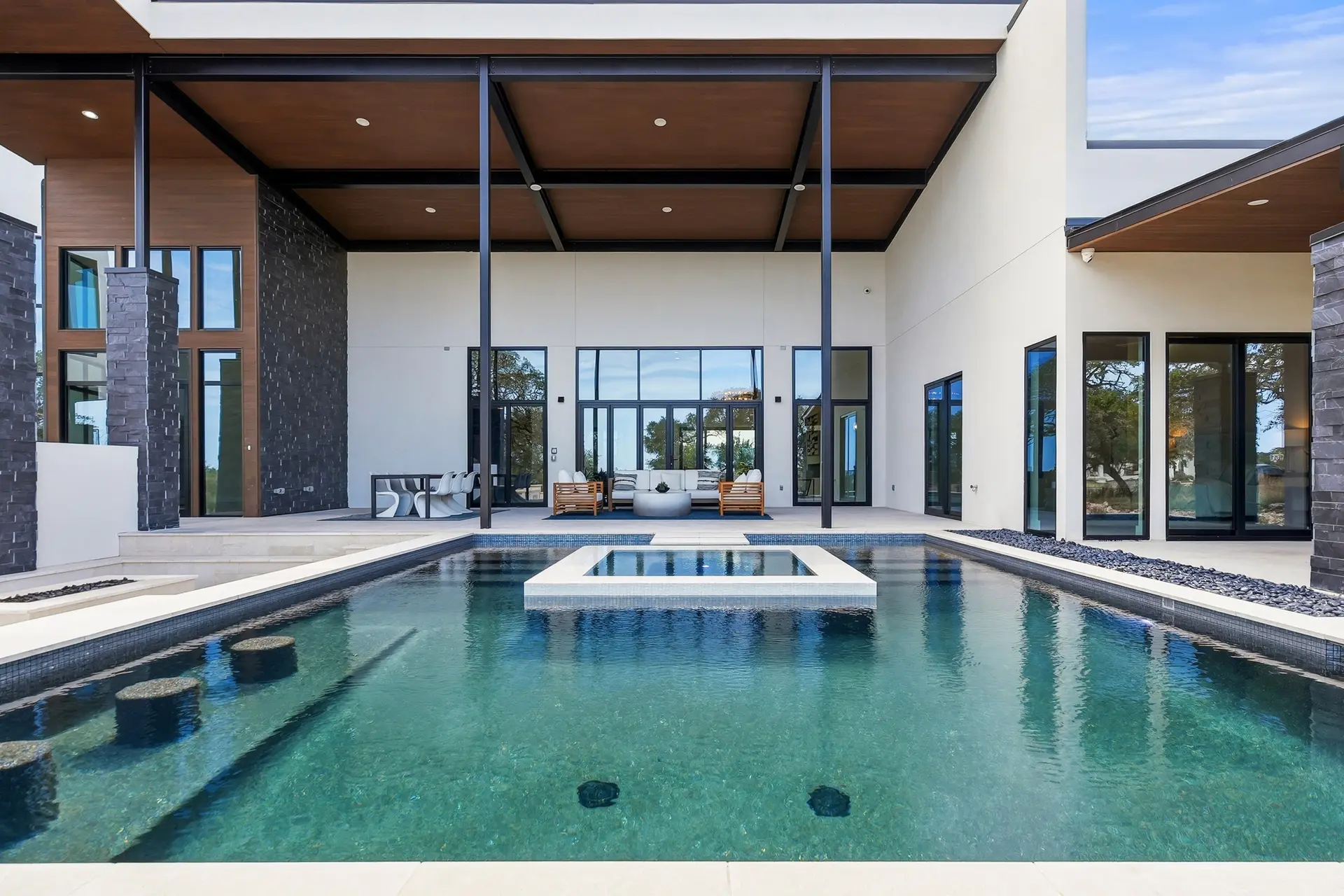 Bluewater Residence swimming pool and spa facing covered patio seating in Lago Vista, Texas