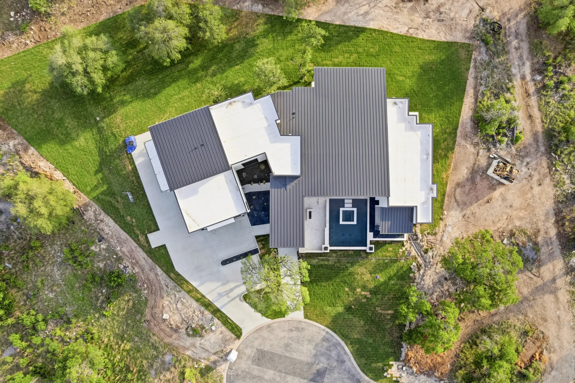 Bluewater Residence aerial top view of roofline, pool and driveway in Lago Vista, Texas