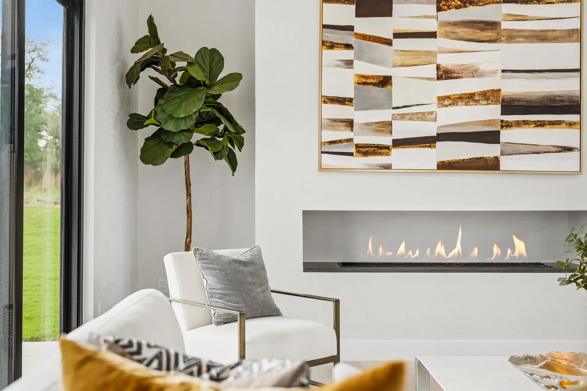 Bluewater Residence living room with linear fireplace and artwork in Lago Vista, Texas