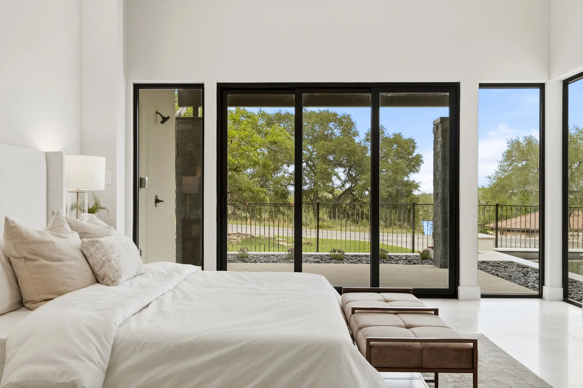 Bluewater Residence bedroom with sliding glass doors to patio and trees in Lago Vista, Texas