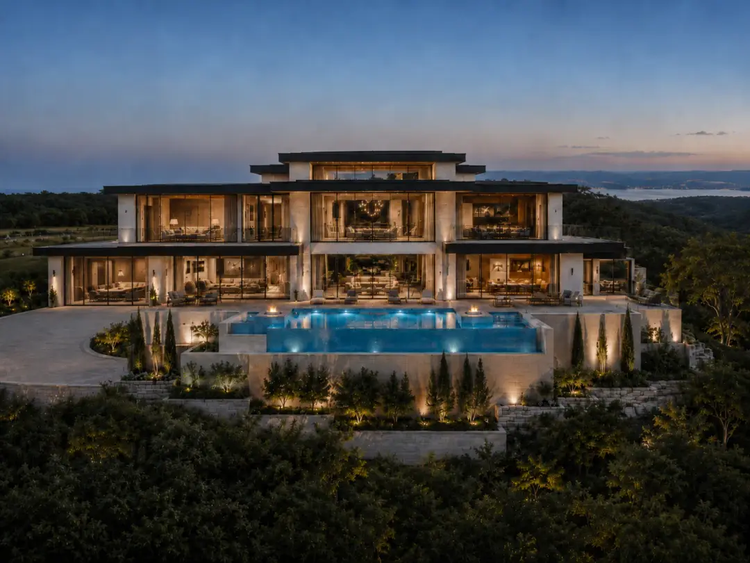 The Ridgeline Estate rear elevation with infinity pool and hillside terraces at dusk in Lago Vista, Texas